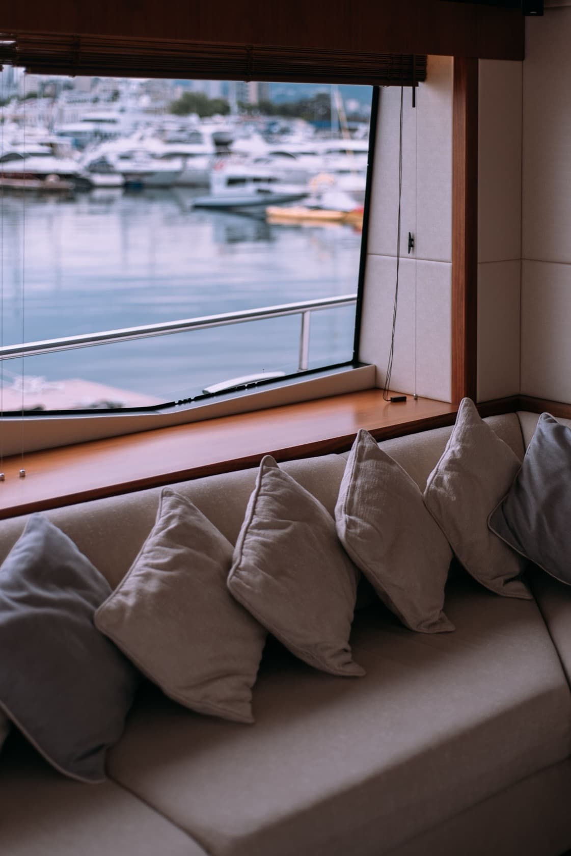 Sillón con cojines junto a la ventana del salón de un yate