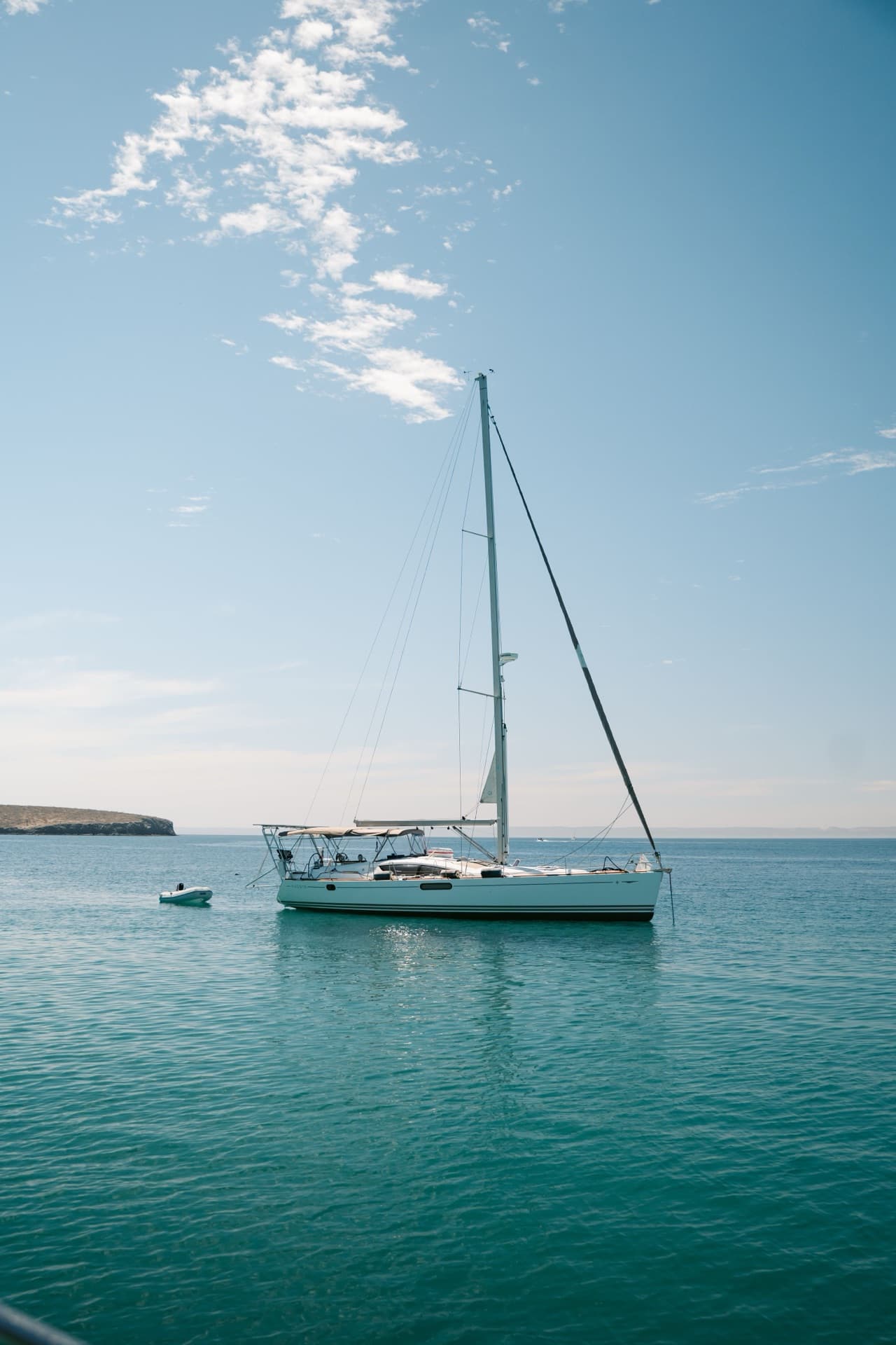 White sailboat at anchor in blue-green water