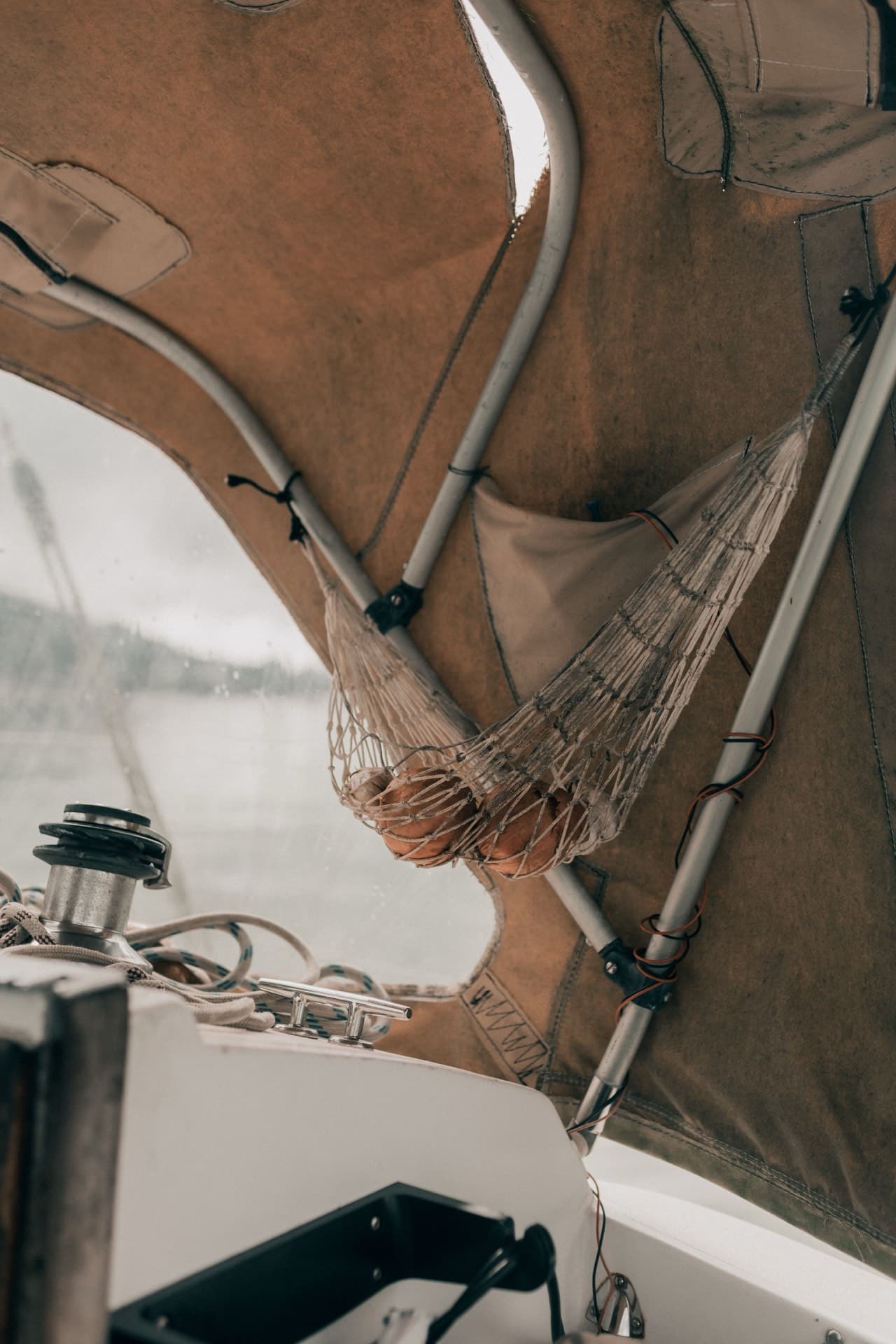 Canvas shade over a sailboat's cockpit, with a net hammock